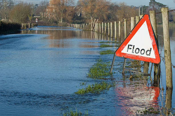 flood risk warning sign over waterlogged field